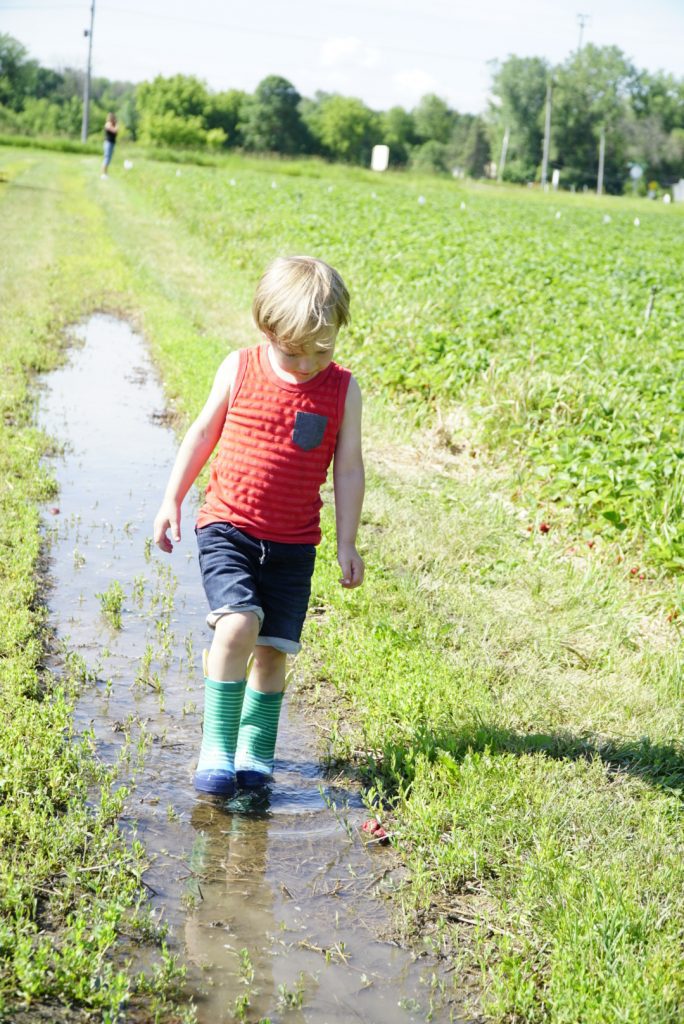toddler walking in puddle at Basse's farm